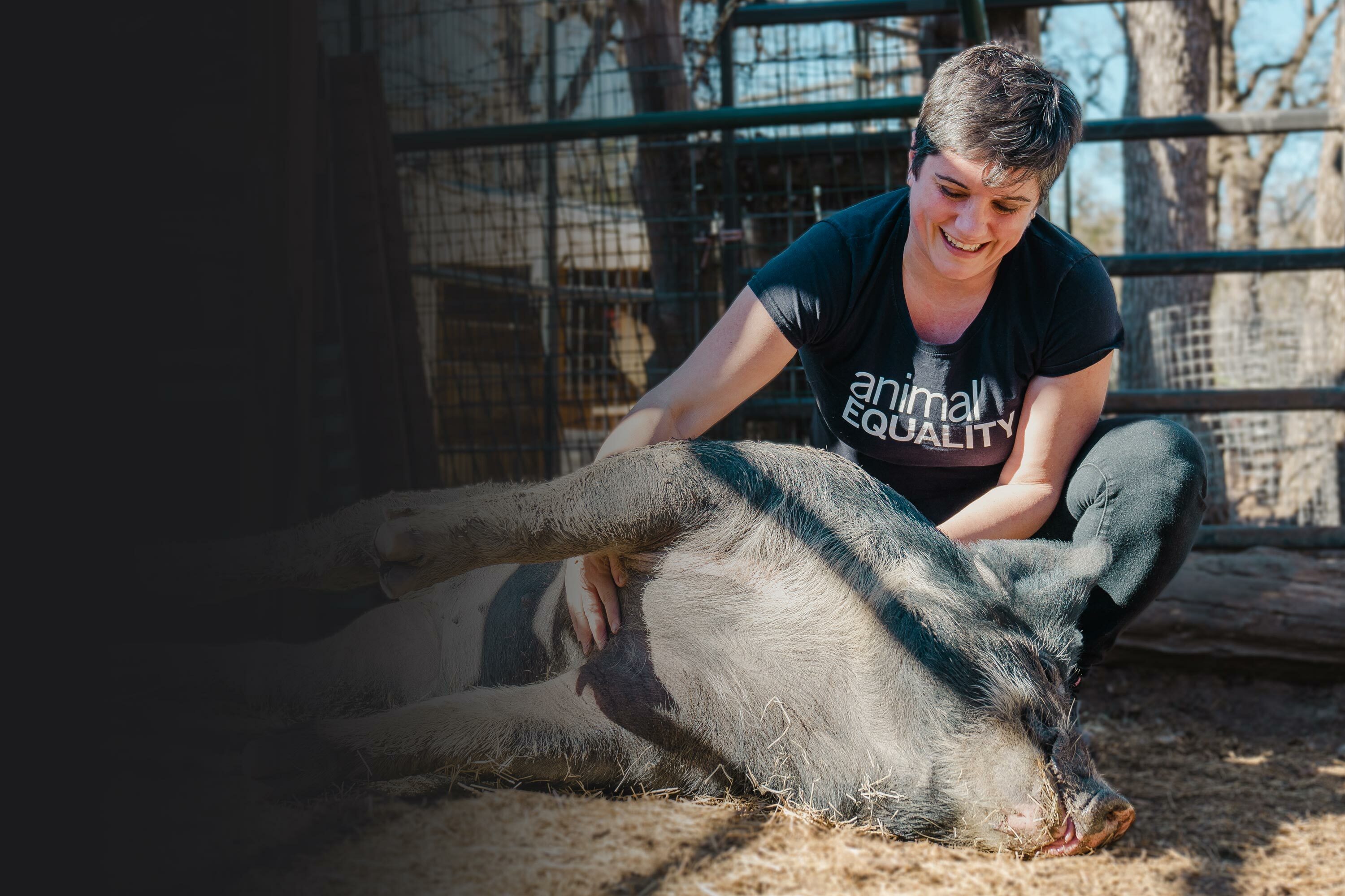 Sharon Nunez holding a pig at an animal sanctuary