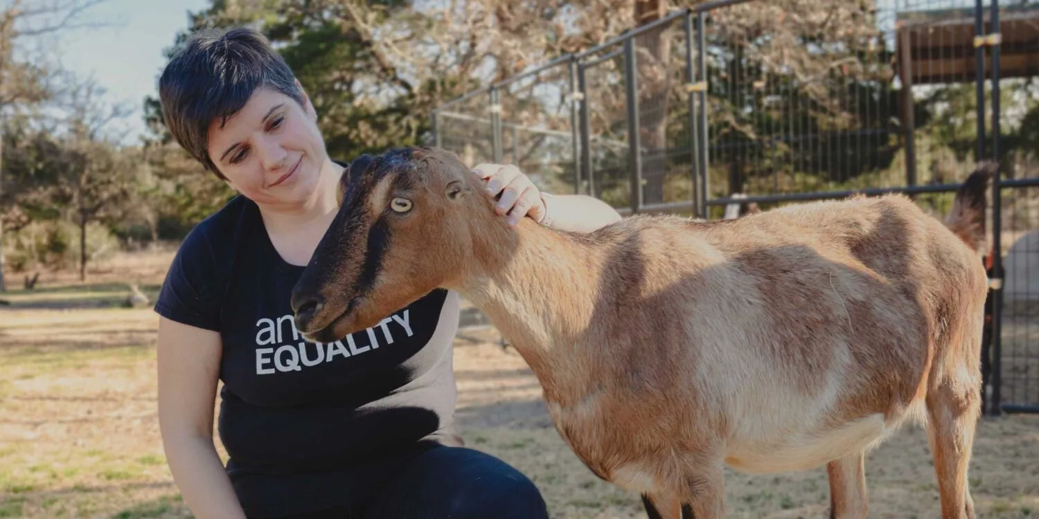 Animal Equality president Sharon Núñez petting a goat.
