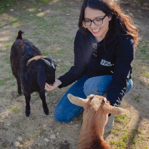 Dulce Ramirez with two goats at a sanctuary