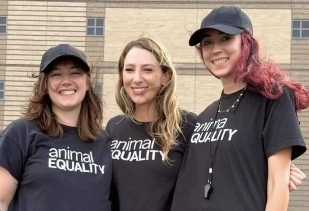 Three Animal Equality activists smile outside a jail after being released.