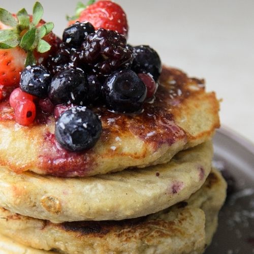 A stack of plant-based pancakes topped with fresh berries.
