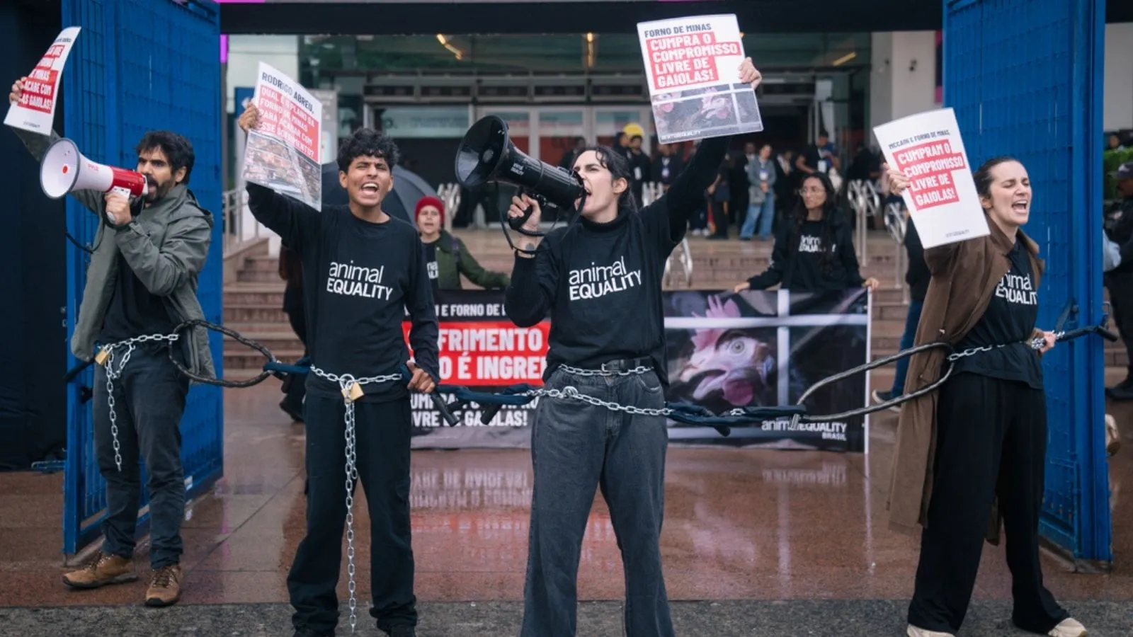 Animal activists are chained together outside of a food expo in Brazil, protesting McCain Foods broken cage-free promise.