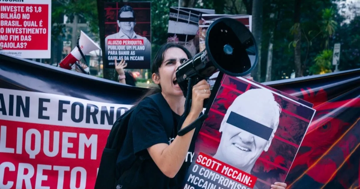 Animal Equality activist holds a protest sign outside McCain Foods' offices in São Paulo, Brazil.