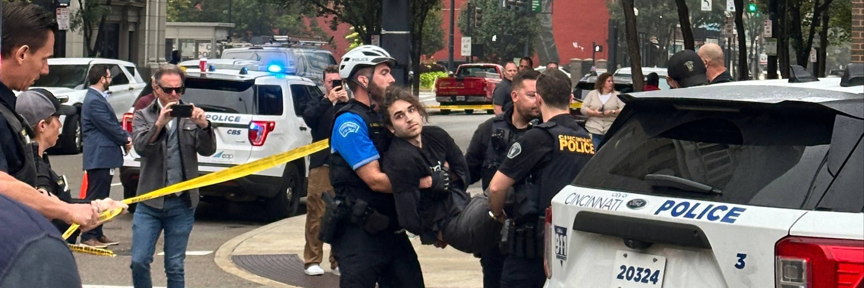 An Animal Equality activist is carried by two police officers during an arrest outside Kroger's headquarters in Cincinnati, Ohio.