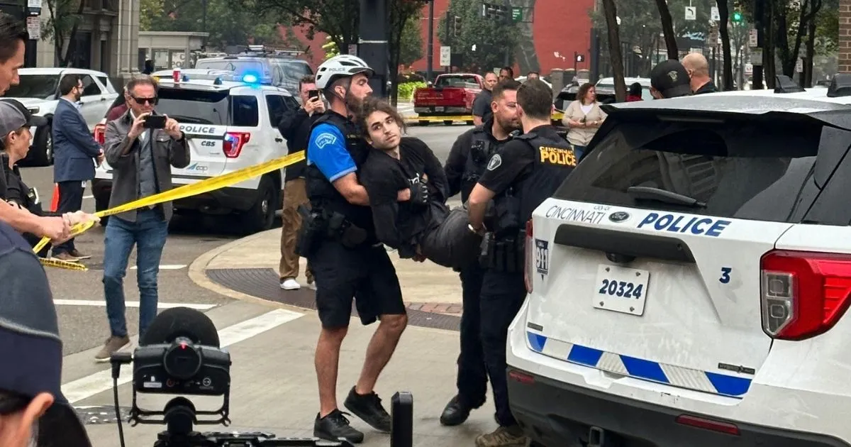 An Animal Equality activist is carried by two police officers during an arrest outside Kroger's headquarters in Cincinnati, Ohio.