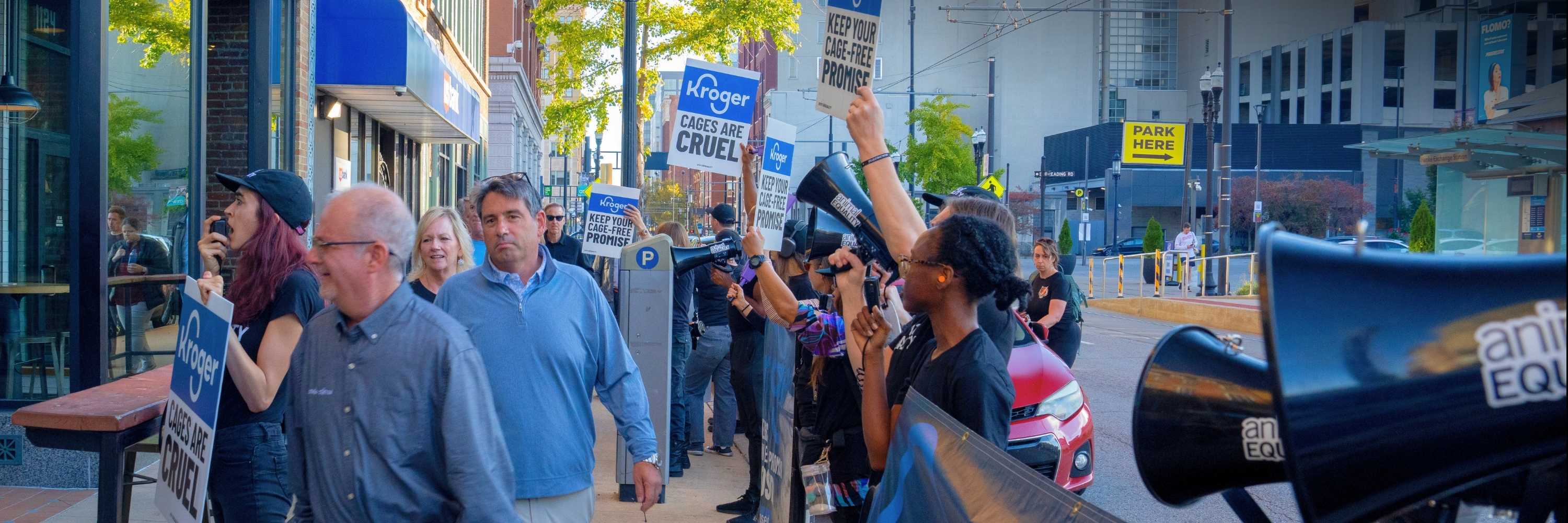 Animal Equality activists protest outside the CMMA opening reception at Pins Mechanical Co. in Cincinnati on October 25, 2026, calling on Kroger to fulfill its broken cage-free commitment.